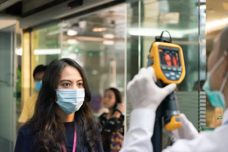 People waiting for temperature check by thermoscan