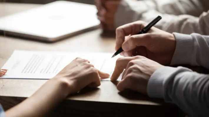 Solicitor pointing at contract showing client where to write signature
