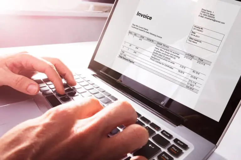 Close-up,Of,Businessman’s,Hands,Working,On,Invoice,On,Laptop,At