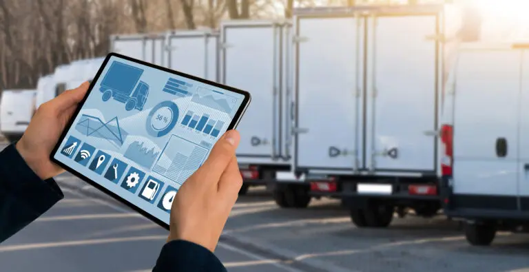 Manager,With,A,Digital,Tablet,On,The,Background,Of,Trucks.