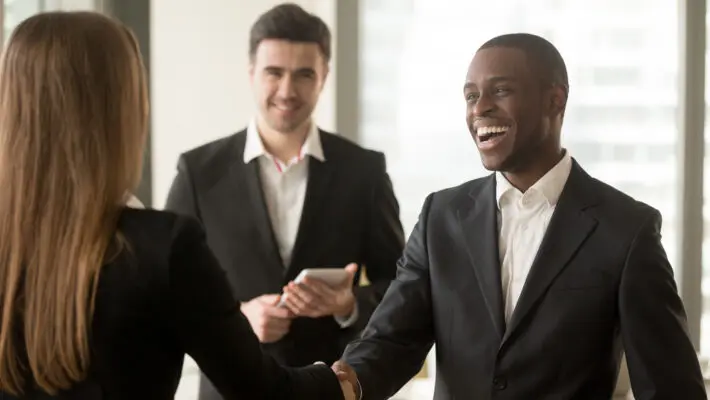 Happy,Smiling,Afro,American,Businessman,And,Caucasian,Businesswoman,Shaking,Hands