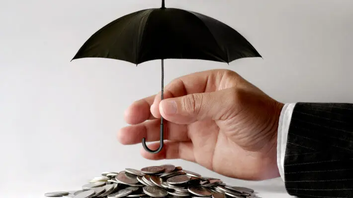 Businessman,Protecting,Coins,With,Umbrella.,Financial,Safety,Concept.