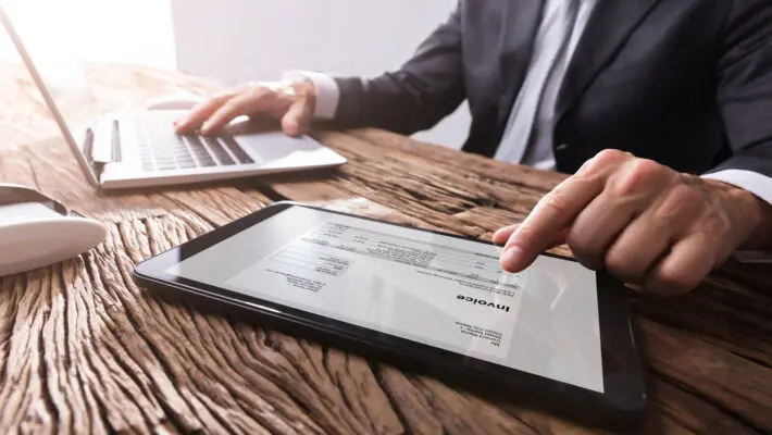 Close-up,Of,A,Businessman’s,Hand,Working,With,Invoice,On,Digital