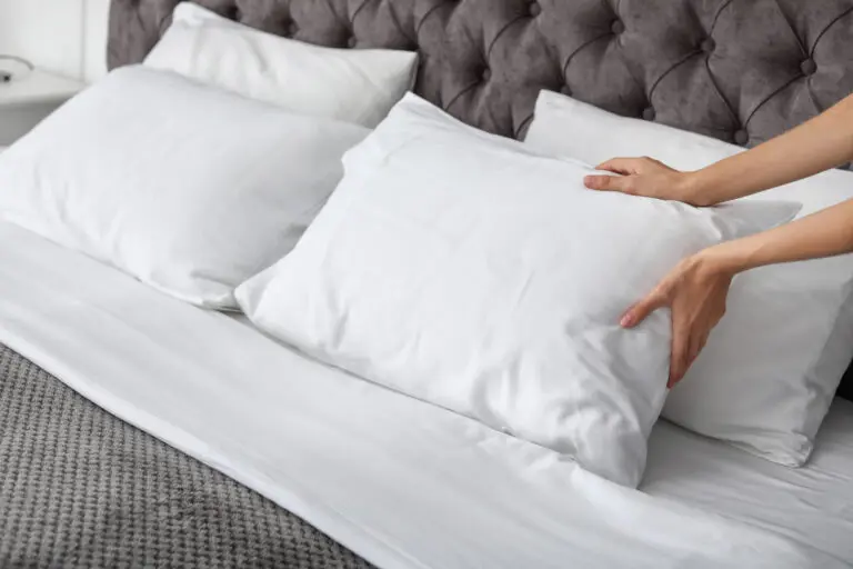 Young,Woman,Plumping,White,Pillow,On,Bed,,Closeup