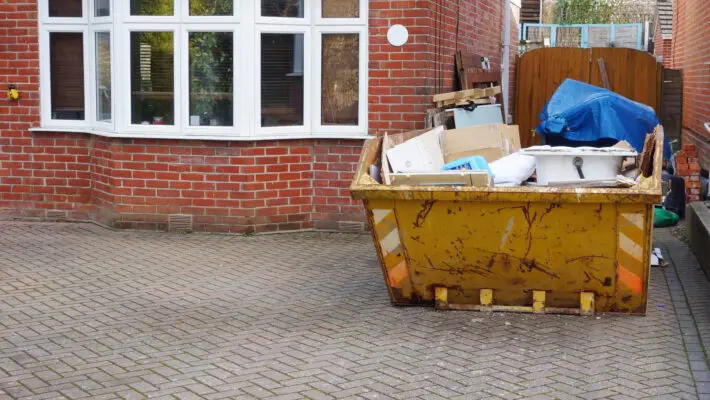 Full,Industrial,Rubbish,Bin,On,Driveway,In,Front,Of,Brick