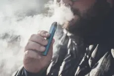 Man,Smokes,New,Vape,Pod,System,,Inhales,And,Exhales,Vapor