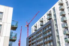 Facade,Of,A,Modern,Flat,With,Building,Cranes,In,The