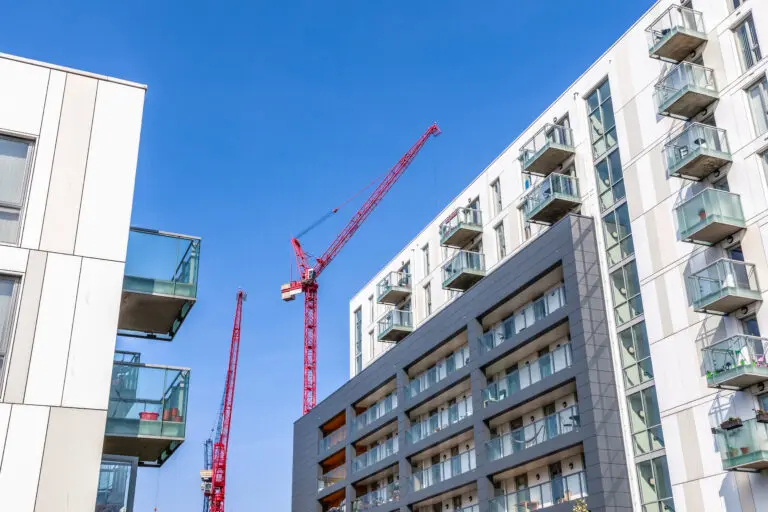 Facade,Of,A,Modern,Flat,With,Building,Cranes,In,The