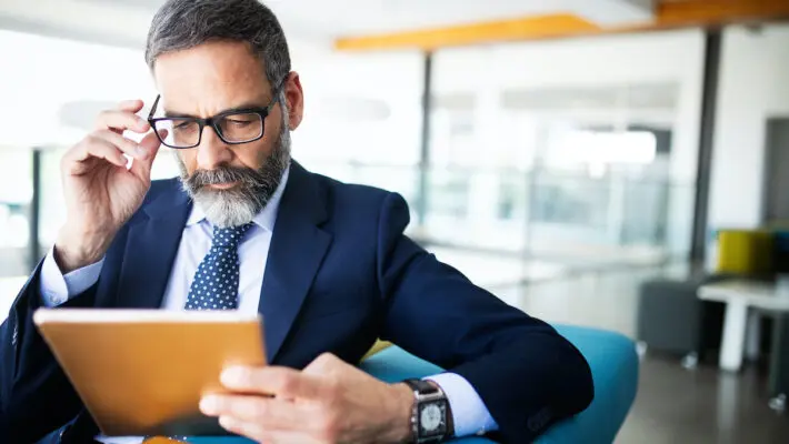 Shot of thinking financial advisor businessman working in office.