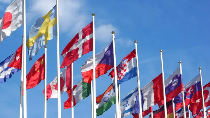 World,Flags,Blowing,In,The,Wind,On,The,Cloudy,Sky