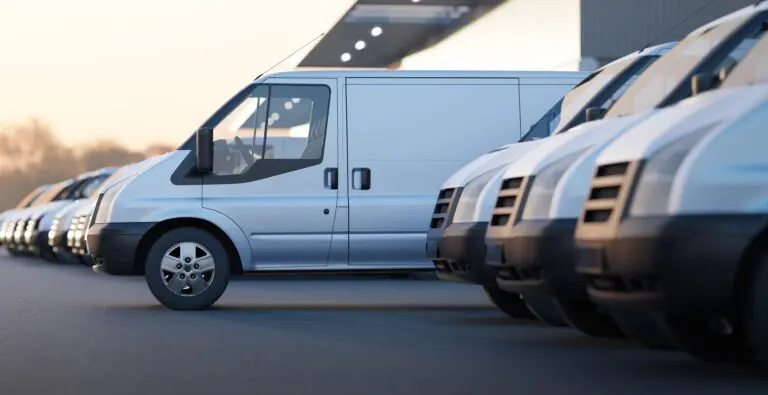 Delivery,Vans,Standing,Out,From,A,Fleet,Of,White,Vans.
