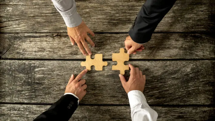 Four,Successful,Business,Men,Joining,Two,Puzzle,Pieces,Each,Being