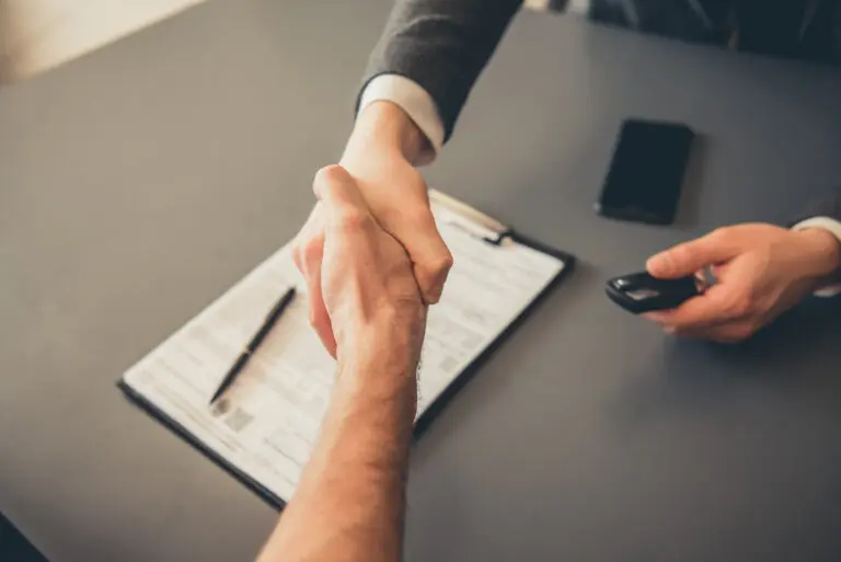 Visiting,Car,Dealership.,Men,Are,Shaking,Hands,While,Signing,Documents