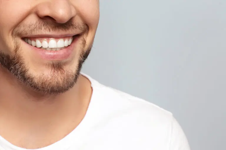 Young,Man,With,Beautiful,Smile,On,Grey,Background.,Teeth,Whitening