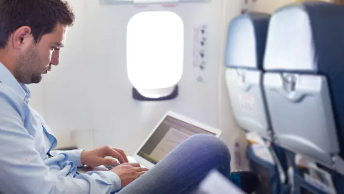 Casually,Dressed,Middle,Aged,Man,Working,On,Laptop,In,Aircraft