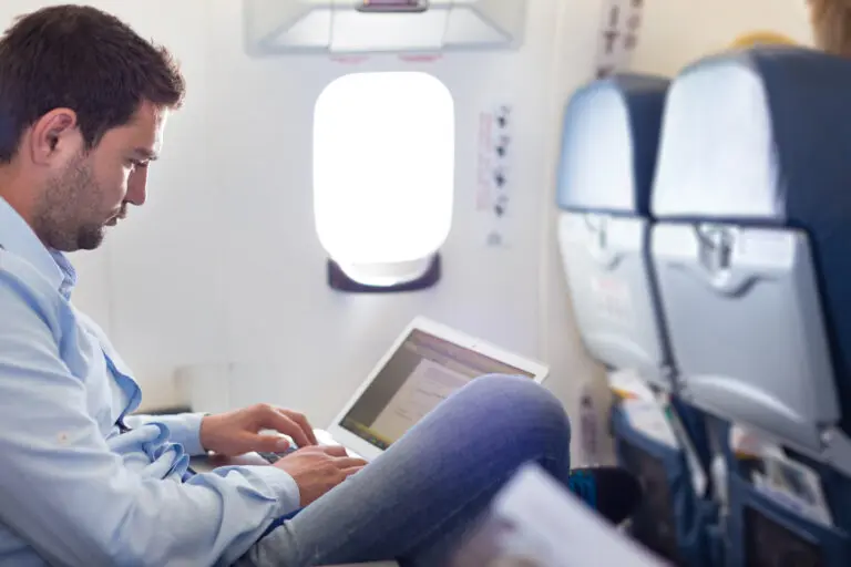 Casually,Dressed,Middle,Aged,Man,Working,On,Laptop,In,Aircraft