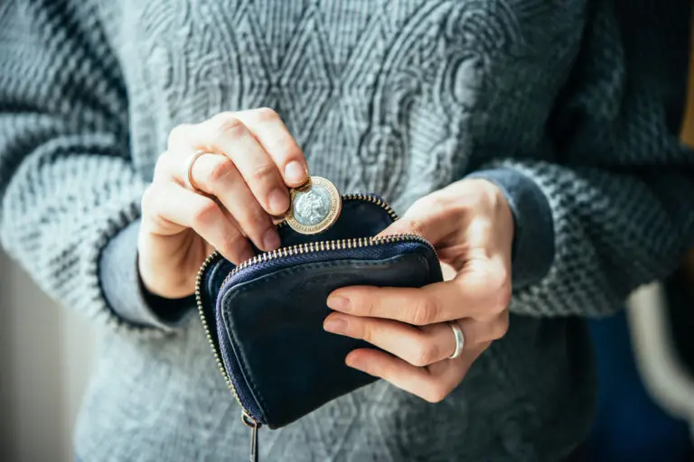 Hands,Holding,British,Pound,Coin,And,Small,Money,Pouch