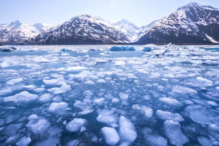 Ice,Melting,In,A,Lake,And,Snow-capped,Mountains,In,Alaska.