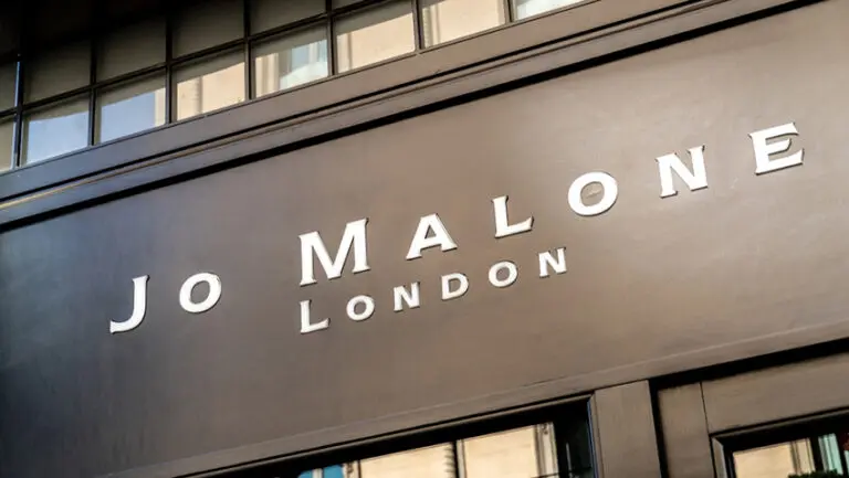 British perfumier Jo Malone is being sued by Estée Lauder Companies for using her own name in a fragrance collaboration with high street retailer Zara, in a legal dispute that highlights the complexities of brand ownership when a founder sells the rights to their name. The American cosmetics giant purchased Malone’s original fragrance business, Jo Malone London, in 1999, acquiring not only the brand but also the commercial rights associated with her name. The deal allowed Estée Lauder to expand the luxury fragrance label globally, but it also placed contractual restrictions on Malone’s ability to use the “Jo Malone” name in connection with fragrance marketing in the future. The latest dispute relates to a collaboration between Zara and Malone’s newer brand, Jo Loves. The partnership, which began in 2019, produced a range of fragrances sold through Zara stores and online platforms. However, Estée Lauder has taken issue with the use of Malone’s name on the product packaging, which reportedly included the wording: “A creation by Jo Malone CBE, founder of Jo Loves.” Estée Lauder claims the wording breaches the terms agreed when Malone sold her original company. The group has filed legal action against Malone personally, her Jo Loves business and Zara’s UK arm, alleging trademark infringement, breach of contract and “passing off” — a legal claim that customers may be misled into believing the products are linked to the Jo Malone London brand. A spokesperson for Estée Lauder Companies said Malone had accepted clear contractual obligations when she sold the company more than two decades ago. The spokesperson said she had been compensated as part of the agreement and had complied with its terms for many years. They added that while Malone is free to pursue new business ventures, the company would act to protect the brand it had invested in building if contractual terms were breached. Zara UK has declined to comment on the case, and Malone has yet to publicly respond to the claims. Malone originally founded her fragrance business in the early 1990s, developing a reputation for distinctive scents inspired by British nature, gardens and seasonal ingredients. The brand quickly gained popularity for its elegant fragrances and minimalist design, expanding into candles, bath products and home fragrances before its acquisition by Estée Lauder. Following the sale, the brand grew into a global luxury fragrance powerhouse with boutiques around the world. However, Malone eventually stepped away from the company she founded. In 2011 she returned to the fragrance industry by launching Jo Loves, a new brand designed to reflect her continued passion for scent creation. The business focuses on niche fragrances and lifestyle products and operates independently of Jo Malone London. Despite this separation, the current lawsuit suggests Estée Lauder believes the Zara collaboration blurred the distinction between the two brands by prominently referencing Malone’s name in connection with fragrance products. The collaboration with Zara brought Malone’s fragrance expertise to a broader audience, with perfumes priced significantly lower than traditional luxury fragrances. Zara has increasingly developed partnerships with well-known perfumers as it expands its lifestyle and beauty offerings. However, the presence of Malone’s name on the packaging appears to have triggered legal concerns for Estée Lauder, which remains highly protective of the Jo Malone London trademark. Malone has previously spoken about regretting the decision to sell the commercial rights to her name when she sold the original company. Such arrangements are common in industries such as fashion and beauty, where founders’ names often become powerful global trademarks. When those brands are sold, the acquiring company typically retains exclusive rights to use the name within certain commercial categories. The dispute now places the focus on how those contractual restrictions should be interpreted. The case is expected to examine whether the wording used in the Zara collaboration constitutes commercial use of the “Jo Malone” name in a way that violates the original agreement. Trademark disputes involving personal names are relatively common in the luxury goods sector, particularly when founders attempt to launch new businesses in the same industry after selling their original brands. For Estée Lauder, the Jo Malone London label remains one of its most successful fragrance brands, making the protection of its intellectual property a priority. For Malone, the case highlights the long-term implications of selling a brand built around a personal identity. The legal proceedings are likely to centre on whether consumers could reasonably be confused about the origins of the fragrances and whether Malone’s involvement in the Zara collaboration breached the restrictions set out in the original sale agreement. The outcome could have wider implications for entrepreneurs who sell businesses tied closely to their own names, particularly in industries where branding and personal reputation are deeply intertwined.
