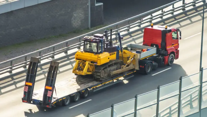 Buying heavy machinery is the fun part. You find that perfect John Deere combine or Caterpillar excavator, negotiate the price, and close the deal. Then reality hits. You have a 40,000-pound piece of metal sitting in Kansas, and you need it in Oregon.