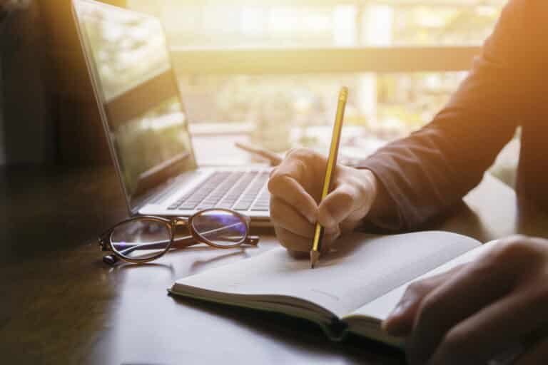 Young,Male,Student,Writes,Information,From,Portable,Net-book,While,Prepare