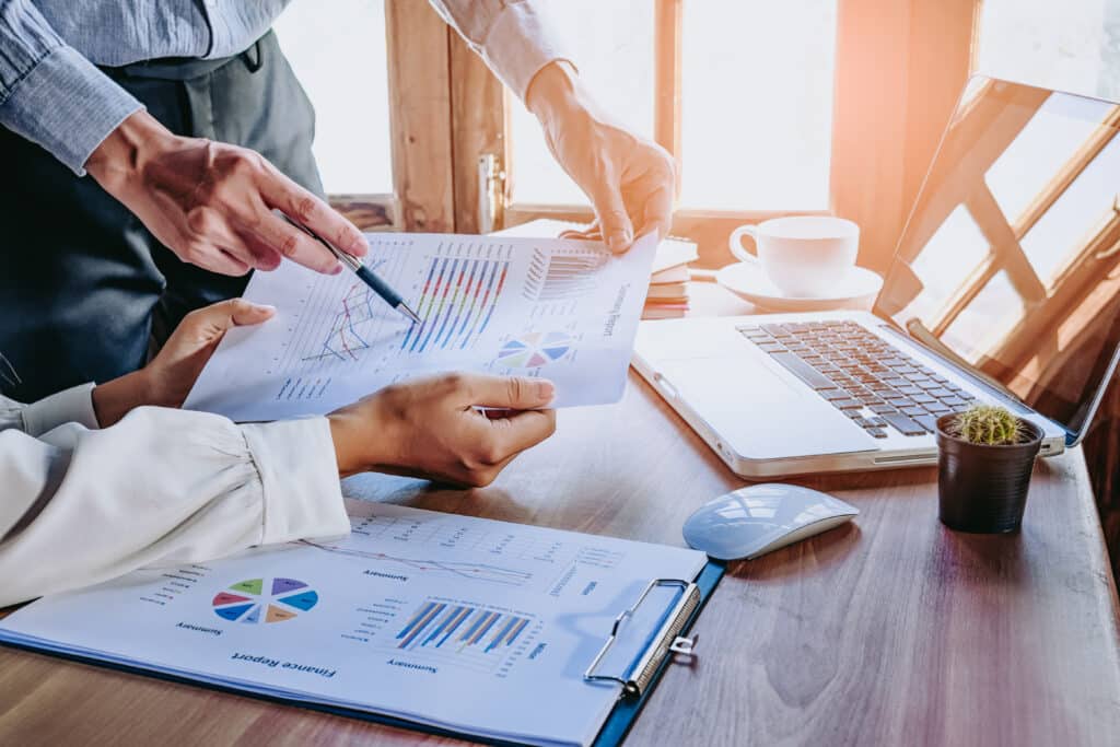 Business,Team,Analyzing,Income,Charts,And,Graphs,With,Modern,Laptop