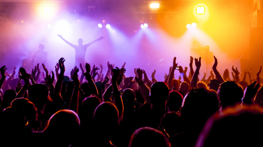 Silhouettes,Of,Concert,Crowd,In,Front,Of,Bright,Stage,Lights