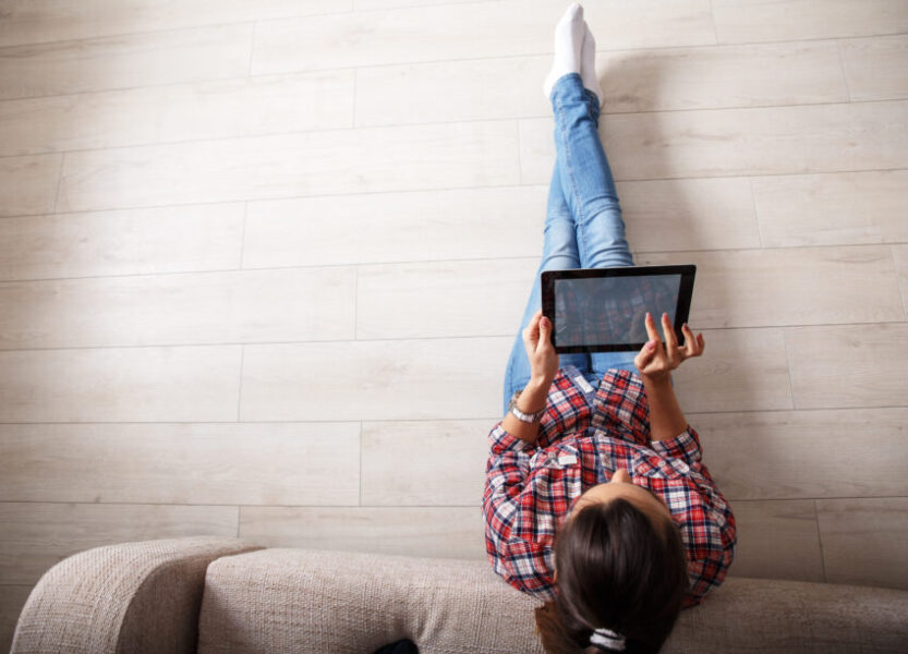 Young,Woman,Sitting,On,Floor,And,Using,Notebook.view,From,Above.