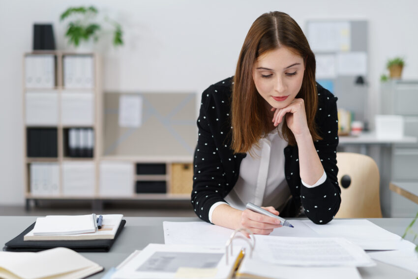 Attractive,Young,Office,Woman,Working,On,The,Business,Papers,While