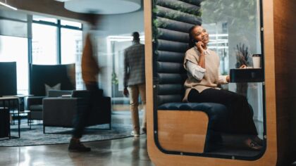 Walk through almost any UK office on a busy Tuesday and you will see the same scene: every meeting room booked, half of them holding a single person on a video call.